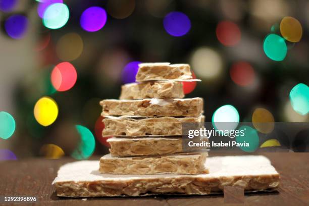 spanish almond nougat or turron de almendras with christmas lights - marzipan stock pictures, royalty-free photos & images