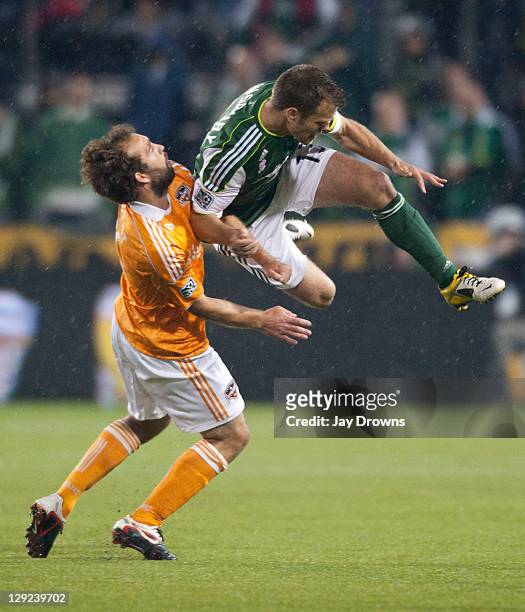 Adam Moffat of the Houston Dynamo collides with Jack Jewsbury of the Portland Timbers during the first half at Jeld-Wen Field on October 14, 2011 in...