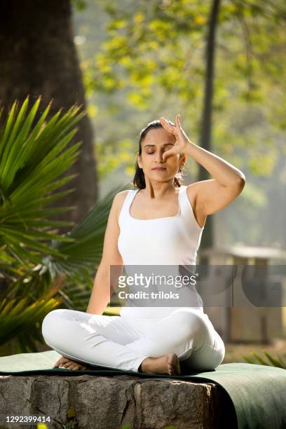 woman meditating at park - zen stock pictures, royalty-free photos & images
