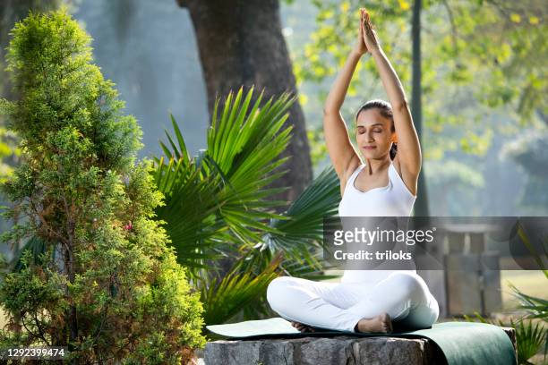 woman meditating at park - yoga stock pictures, royalty-free photos & images