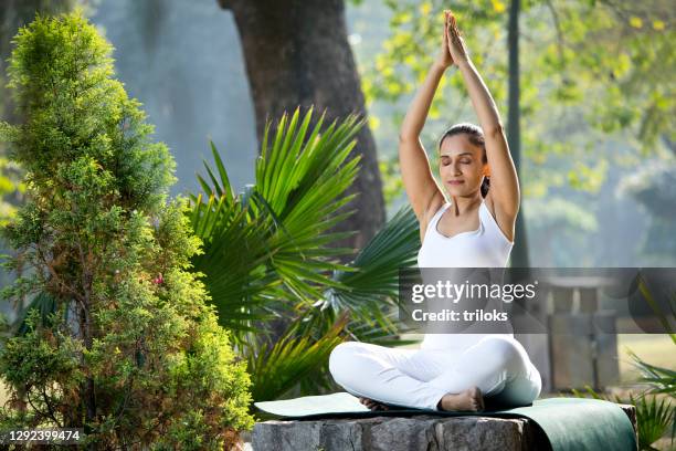 woman meditating at park - buddhism india stock pictures, royalty-free photos & images