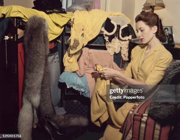 Scottish actress Deborah Kerr wears a wool afternoon dress in maize, with a narrow revered jacket which is draped over the hips and trimmed with tiny...