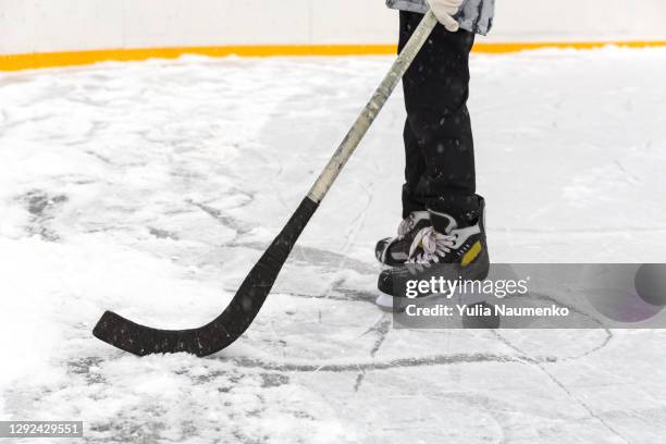 a boy ice hockey amateur player with a stick on ice. close-up. - hockey kids stock-fotos und bilder