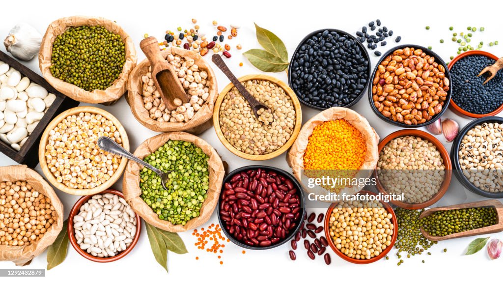 Large variety of dried beans, legumes and cereals shot from above on white background