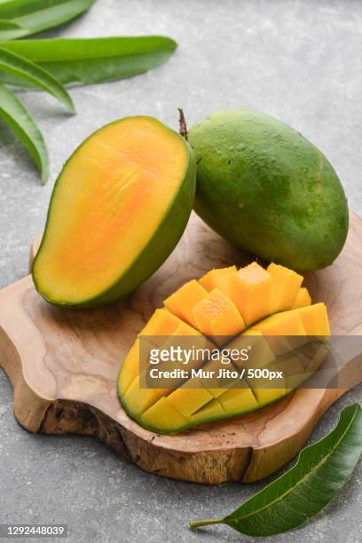 high angle view of mangoes on cutting board - mango stock-fotos und bilder