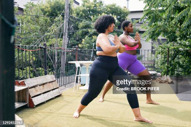 Two body positive women practicing yoga together