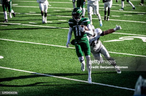 Denzel Mims of the New York Jets runs the ball past Nick Kwiatkoski of the Las Vegas Raiders at MetLife Stadium on December 6, 2020 in East...