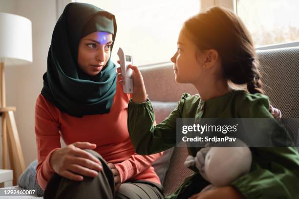 young girl measuring her mother's temperature - ponto de verificação de temperatura imagens e fotografias de stock