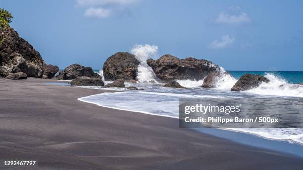 scenic view of rocks on beach against sky,martinique - baron beach stock pictures, royalty-free photos & images