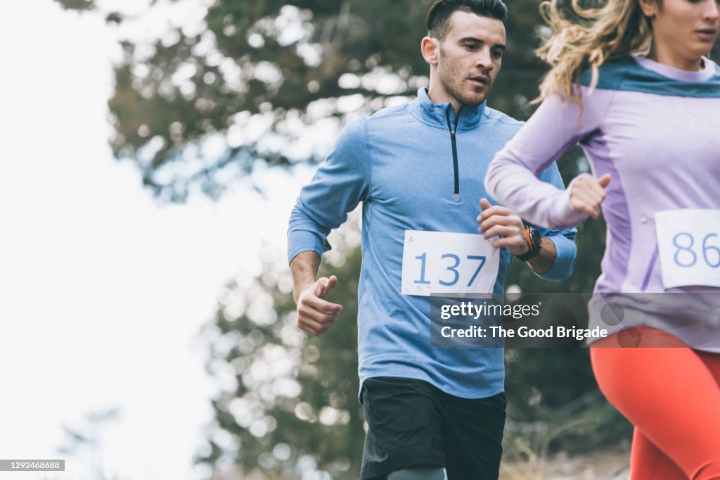 Young male and female athletes running during marathon race