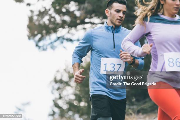 young male and female athletes running during marathon race - bib stock pictures, royalty-free photos & images