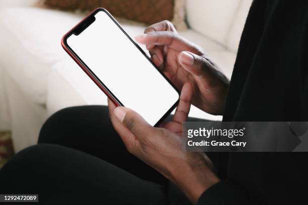 woman lounges on sofa with smart phone - hand stockfoto's en -beelden