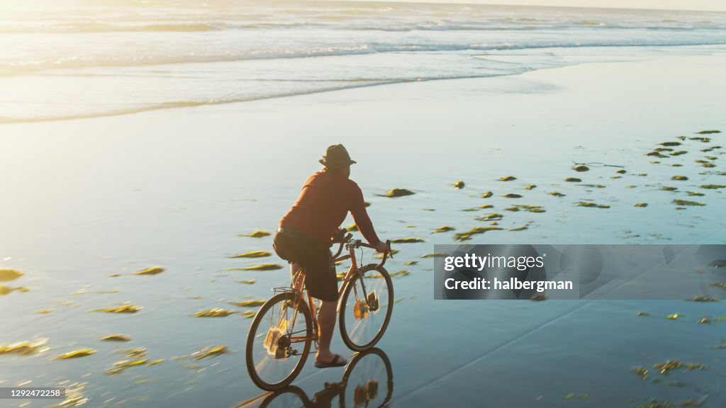 Man Cycling Through Water on Oregon Beach - Drone Shot