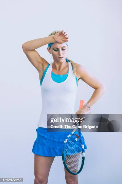 tired female tennis player holding racket against white background - tennis racquet isolated stock pictures, royalty-free photos & images