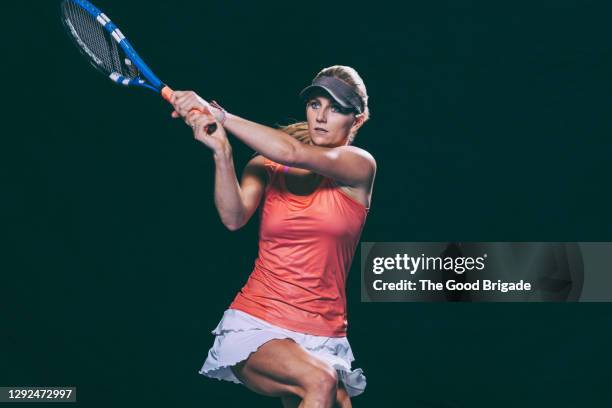 confident female athlete practicing tennis against black background - tennis player stock pictures, royalty-free photos & images