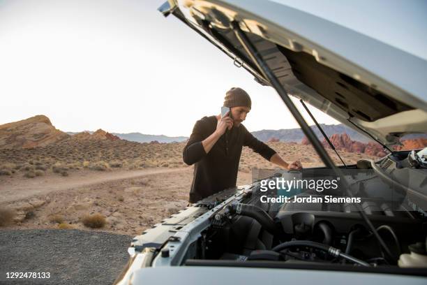 a man making a phone call while having car troubles. - avería de coche fotografías e imágenes de stock