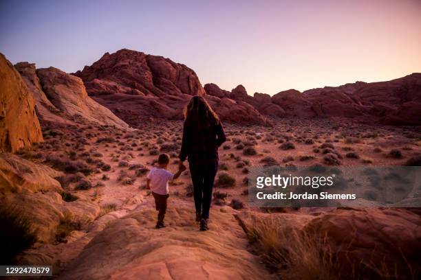 a mother and her son hiking in the desert at dusk. - nevada hiking stock pictures, royalty-free photos & images