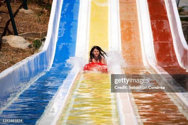 enjoying water slide. teenage girl at water park, going down water slide. - acquapark foto e immagini stock