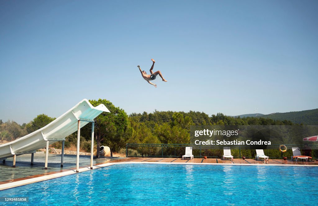 Enjoying water slide. Man making a record jump in the air.