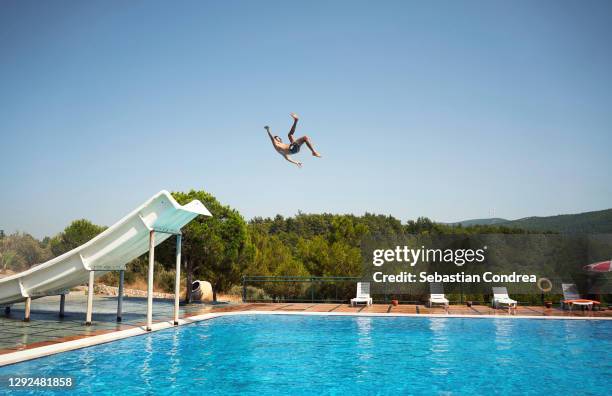 enjoying water slide. man making a record jump in the air. - aquapark stock-fotos und bilder