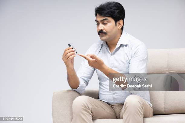 mature man sitting sofa at white background, stock photo - man examining stock pictures, royalty-free photos & images