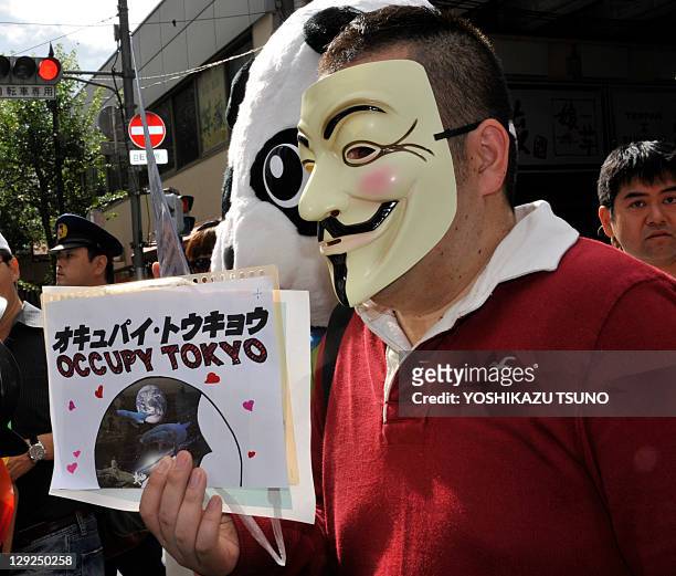 Masked protestor holds a sign during a rally "Occupy Tokyo" as part of a worldwide protest inspired by the "Occupy Wall Street" protest in Tokyo on...
