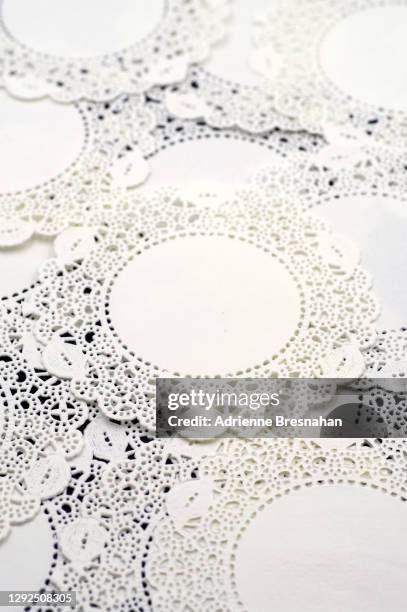 abstract pattern of white lace doilies on a black background - black lace background stock pictures, royalty-free photos & images