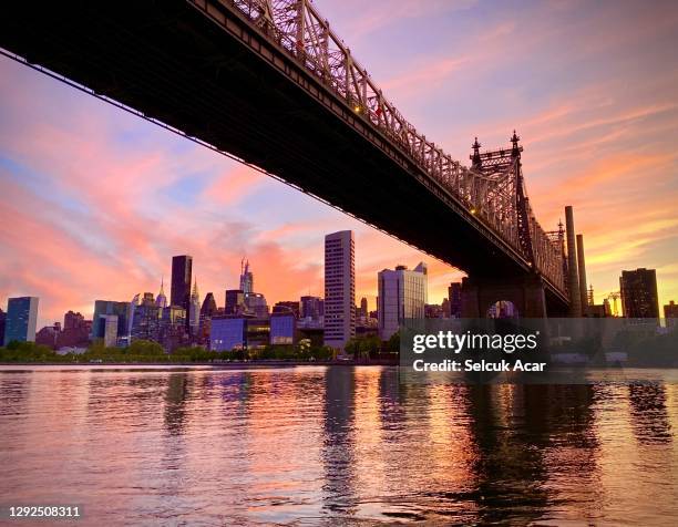 sunset in new york city - クイーンズボロ橋 ストックフォトと画像