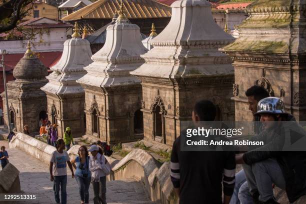 men sitting in front of the small shiva temples in the pandra shivalaya at pashupatinath hindu cremation temple, kathmandu, nepal - sitting shiva stock pictures, royalty-free photos & images