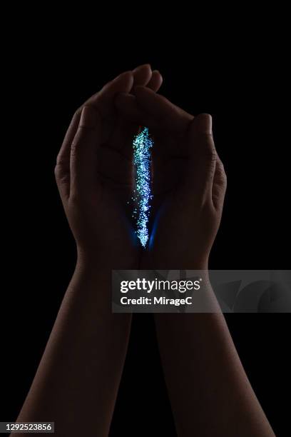 hand holding fiber optics in the dark - mens en machine stockfoto's en -beelden