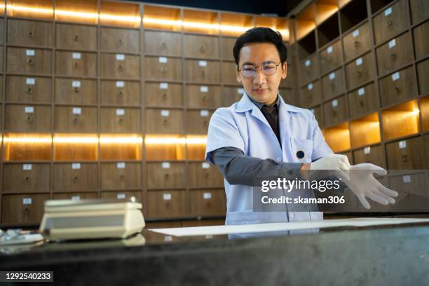 portrait of chinese young male doctor prepare medical equipment for patient  traditional chinese therapy - acupuncture model stock pictures, royalty-free photos & images