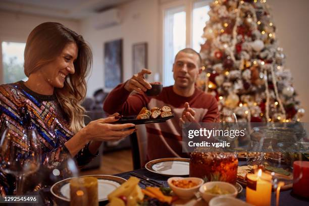 group of friends enjoying christmas dinner at home - adult laughing christmas stock pictures, royalty-free photos & images