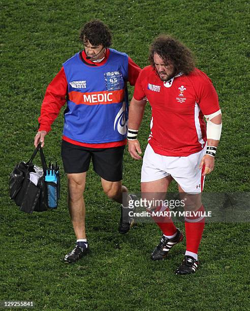 Wales' prop Adam Jones is assisted off the field after an injury during the 2011 Rugby World Cup semi-final match France vs Wales at Eden Park...