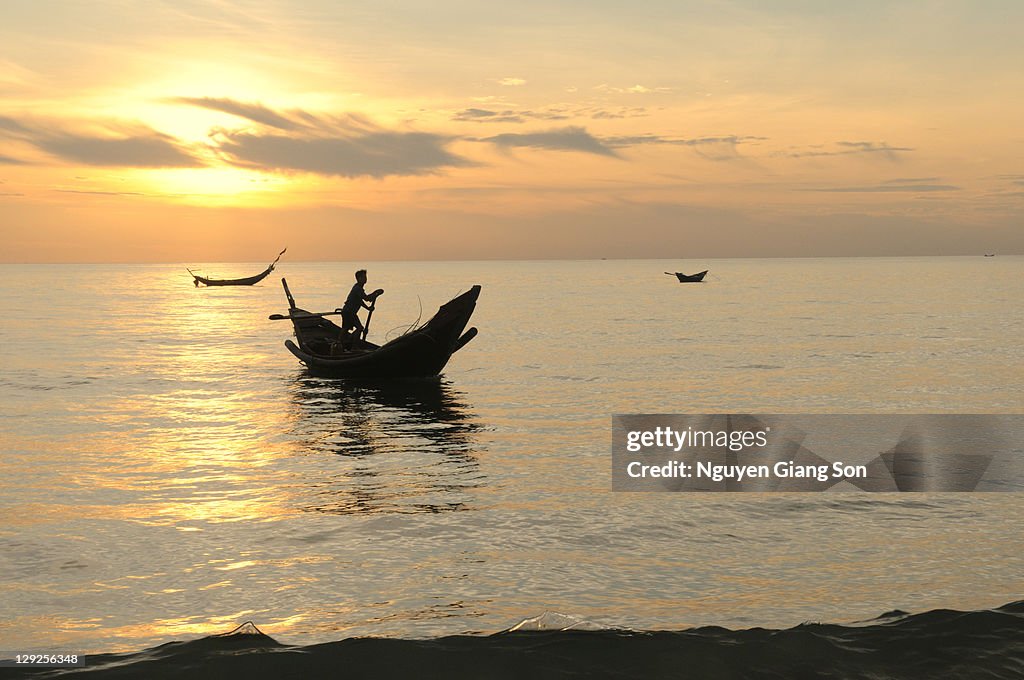 Boat in water at sunrise