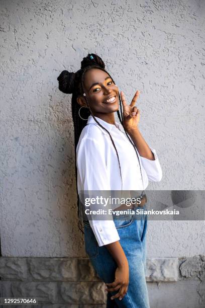 young african american woman posing against wall background. - beautiful black teen girl stock-fotos und bilder