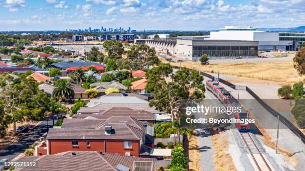 aerial view adelaide metro train on new flinders link with factory & city - adelaide train stock pictures, royalty-free photos & images