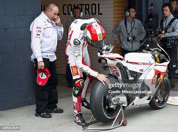 Marco Simoncelli of Italy and San Carlo Honda Gresini looks on the rear tyre at the end of the qualifying practice for the Australian MotoGP, which...