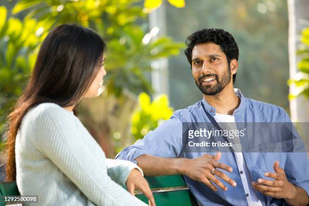 couple discussing at park - beard stock pictures, royalty-free photos & images