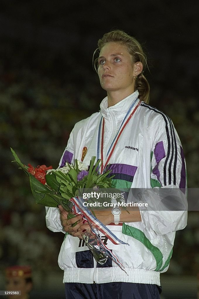 Katrin Krabbe of the German Democratic Republic stands on the podium after winning the gold medal