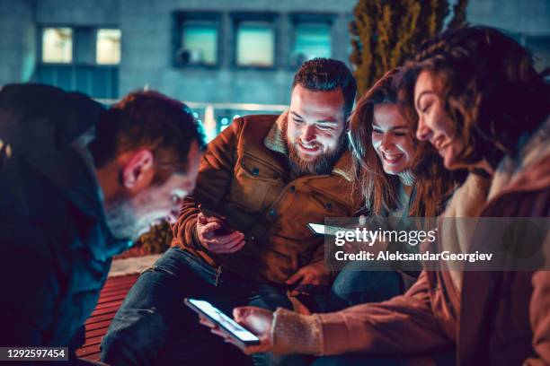 amigos pasando tiempo con teléfonos inteligentes fuera - amistad fotografías e imágenes de stock