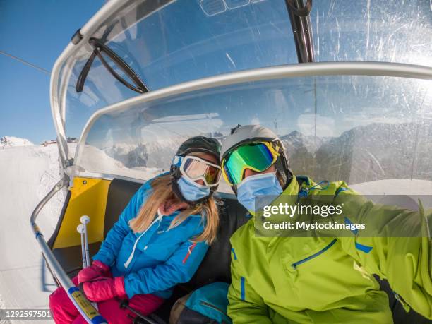 het paar neemt selfie op skilift, covid-19 - couple ski lift stockfoto's en -beelden