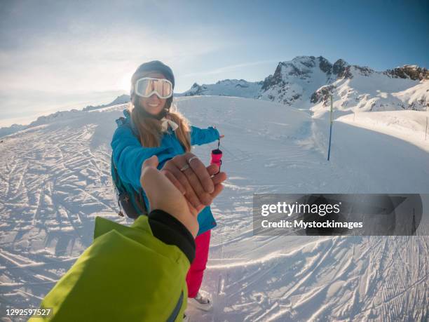 couple holding hands on ski slope - snowboarding pov stock pictures, royalty-free photos & images