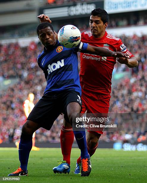 Luis Suarez of Liverpool tussles for posesssion with Patrice Evra of Manchester United during the Barclays Premier League match between Liverpool and...