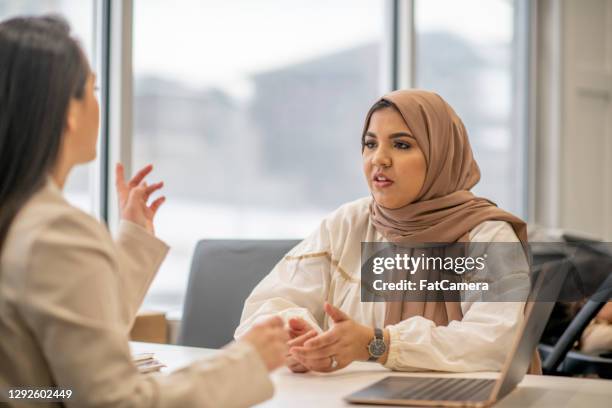 muslimische frau trägt hijab im gespräch mit arzt - humility stock-fotos und bilder