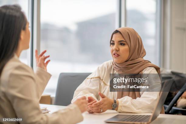 mujer musulmana que lleva hiyab hablando con el médico - humility fotografías e imágenes de stock