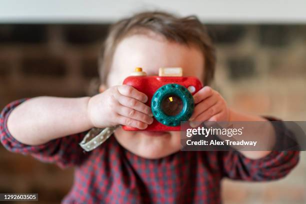 a baby takes a photo on a toy wooden camera - toy camera stock pictures, royalty-free photos & images