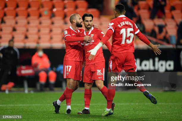 Suso of Sevilla celebrates with teammates Yousseff En-Nesyri and Aleix Vidal of Sevilla FC after scoring their sides first goal during the La Liga...