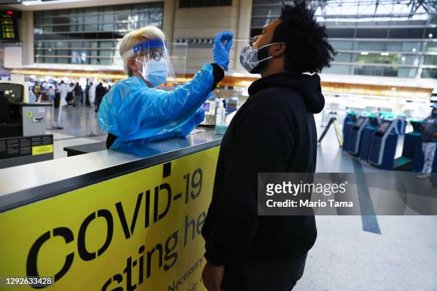Man receives a nasal swab COVID-19 test at Tom Bradley International Terminal at Los Angeles International Airport amid a coronavirus surge in...