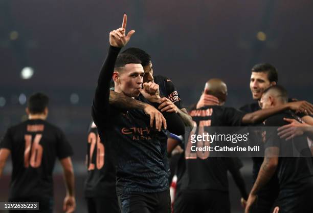 Phil Foden of Manchester City celebrates after scoring their sides third goal with teammate Joao Cancelo during the Carabao Cup Quarter Final match...