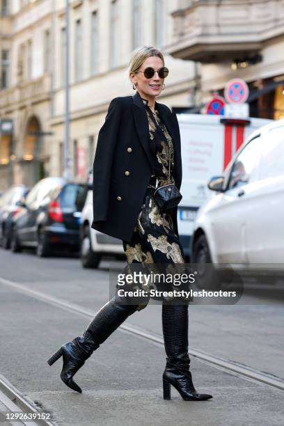 German TV host Tamara von Nayhauss wearing black and gold earrings by Chanel, black and gold round sunglasses by Chanel, a black and gold small bag...